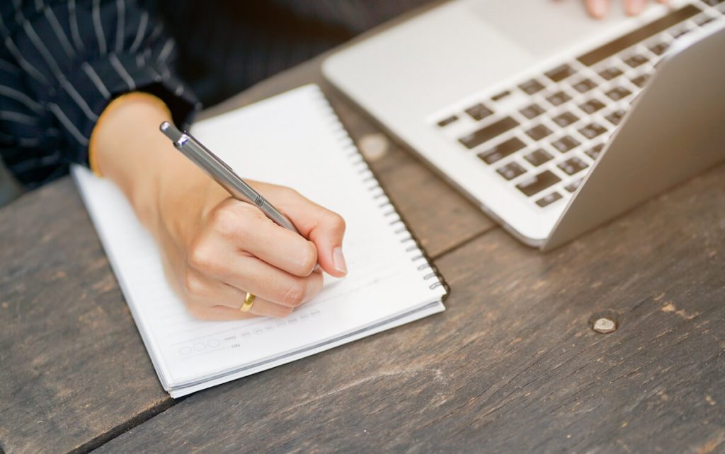 woman writing web copy on notepad